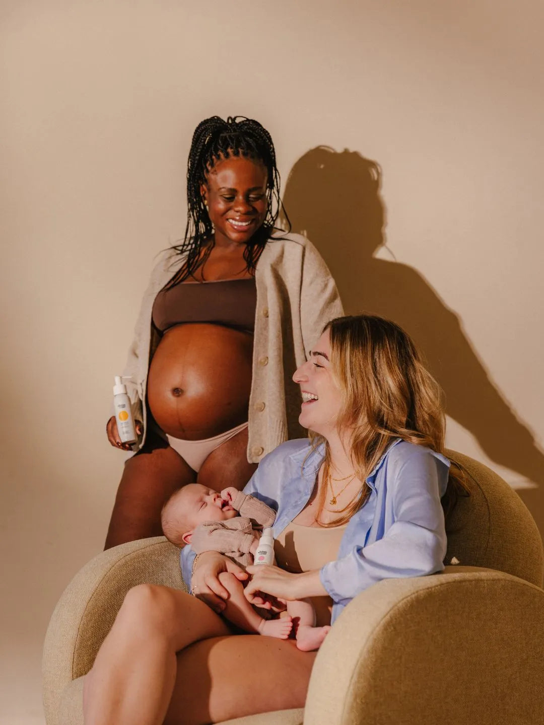 beeld met zwangere en postpartum vrouw en baby die de shinncare producten vasthouden en lachen
